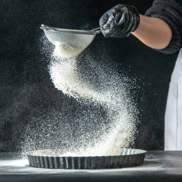 front-view-female-cook-pouring-white-flour-into-pan-dark-egg-cake-bakery-hotcake-kitchen-cuisine-dough-pie (1)